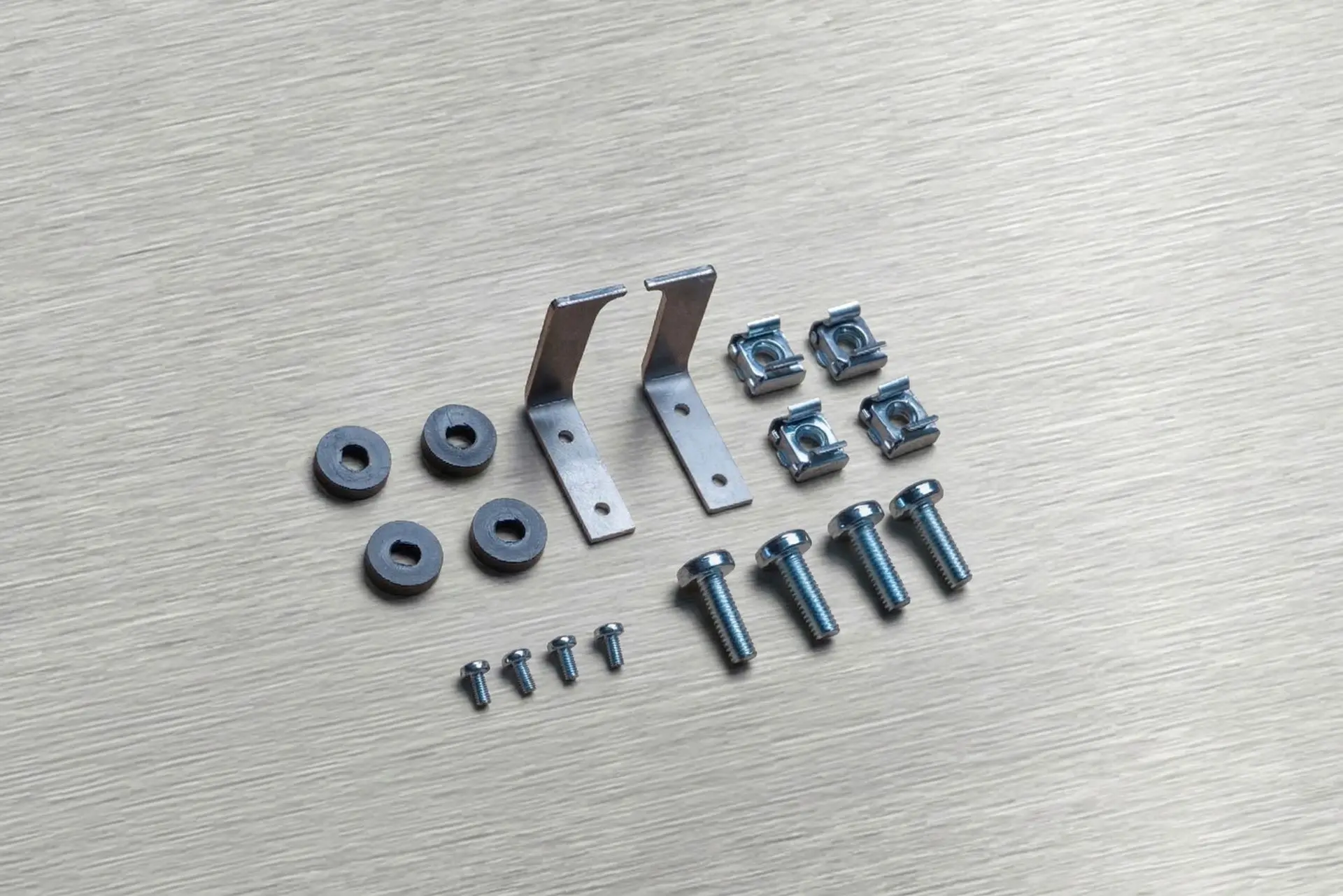 Vorkonfektioniertes Montage-Set von C-SERVE mit Winkelblechen, Käfigmuttern, Schrauben und Dichtungsringen.